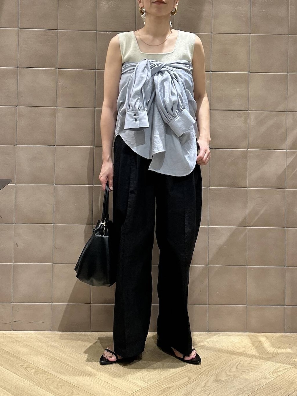 ブラック系のショルダーバッグ、ブルー系のシャツ/ブラウス、ホワイト系のタンクトップを着用したレディースの春コーディネートの10枚目の写真