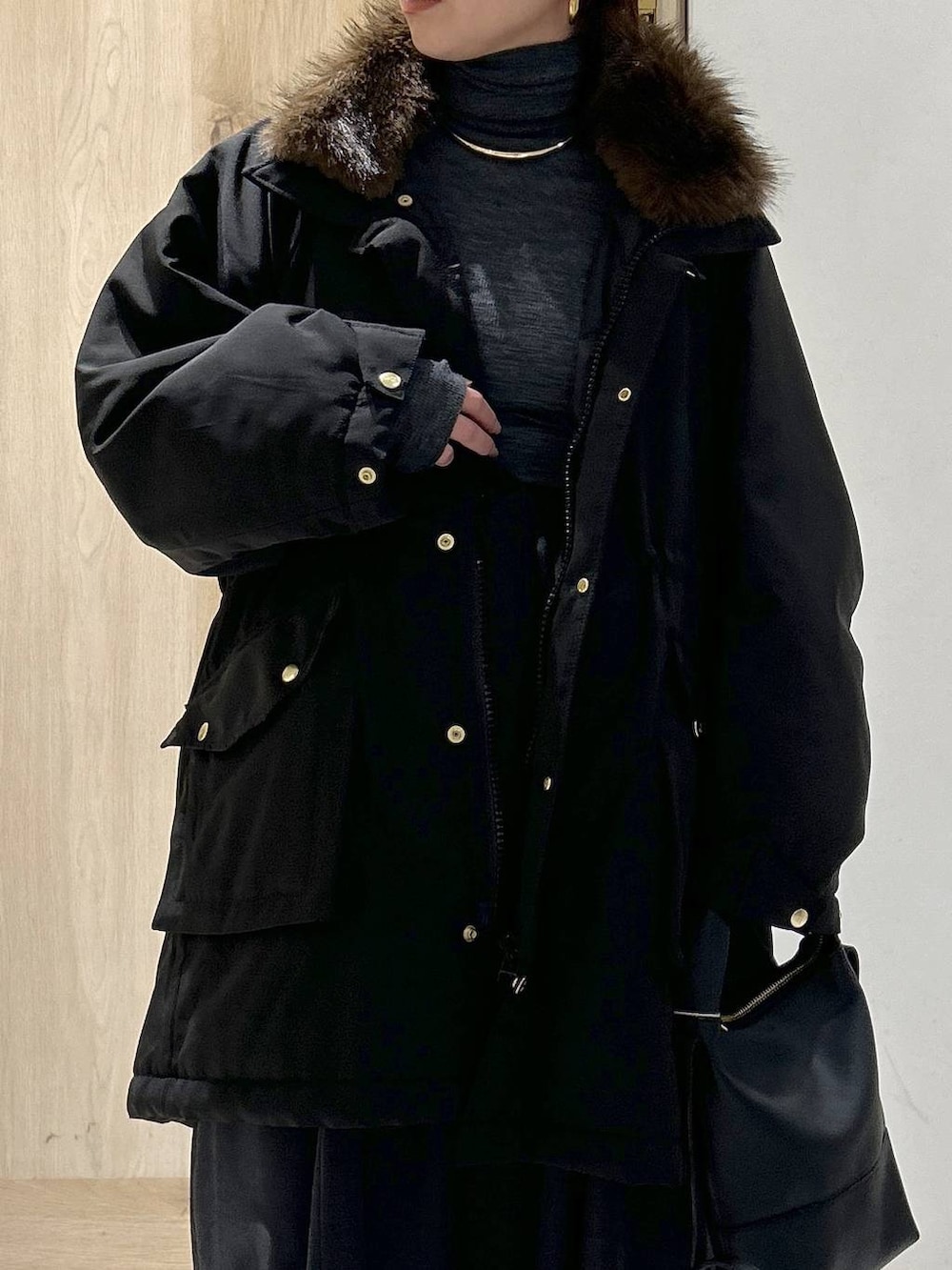 ブラック系のショルダーバッグ、ブラック系のモッズコート、グレー系のニット/セーターを着用したレディースの秋コーディネートの7枚目の写真