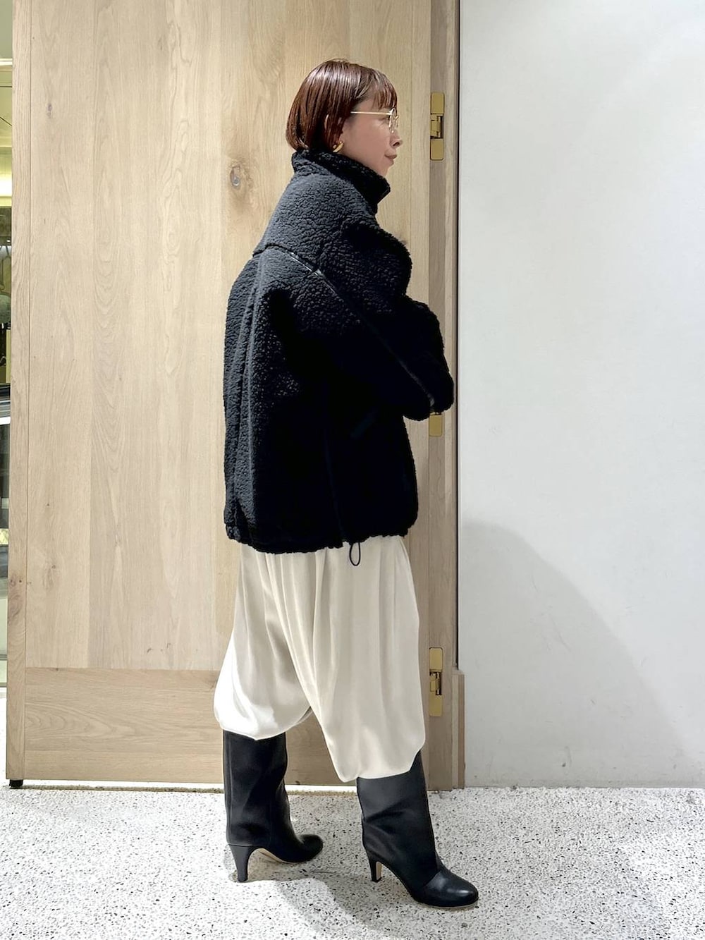 ブラック系のトートバッグ、ブラック系のブルゾン、ホワイト系のカーディガン/ボレロを着用したレディースの秋コーディネートの4枚目の写真