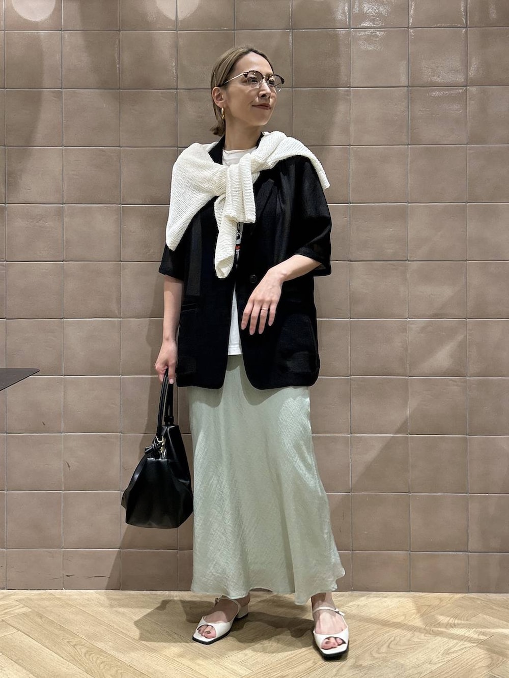 ブラック系のショルダーバッグ、ホワイト系のTシャツ/カットソー、ホワイト系のパンプスを着用したレディースの夏コーディネートの5枚目の写真
