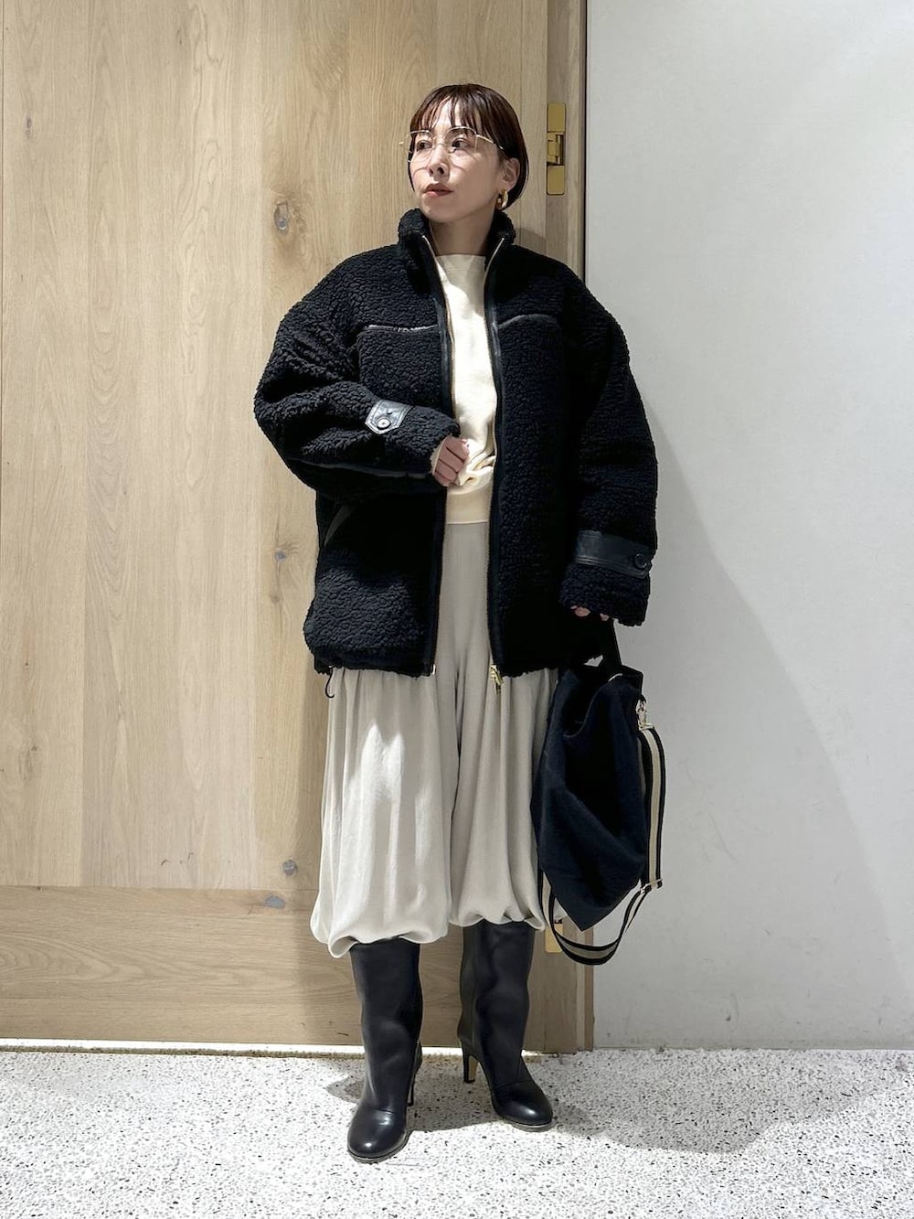 ブラック系のトートバッグ、ブラック系のブルゾン、ホワイト系のカーディガン/ボレロを着用したレディースの秋コーディネートの5枚目の写真