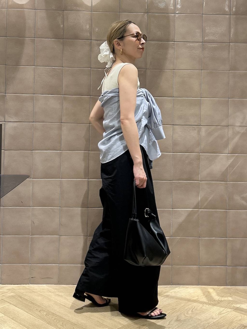 ブラック系のショルダーバッグ、ブルー系のシャツ/ブラウス、ホワイト系のタンクトップを着用したレディースの春コーディネートの8枚目の写真
