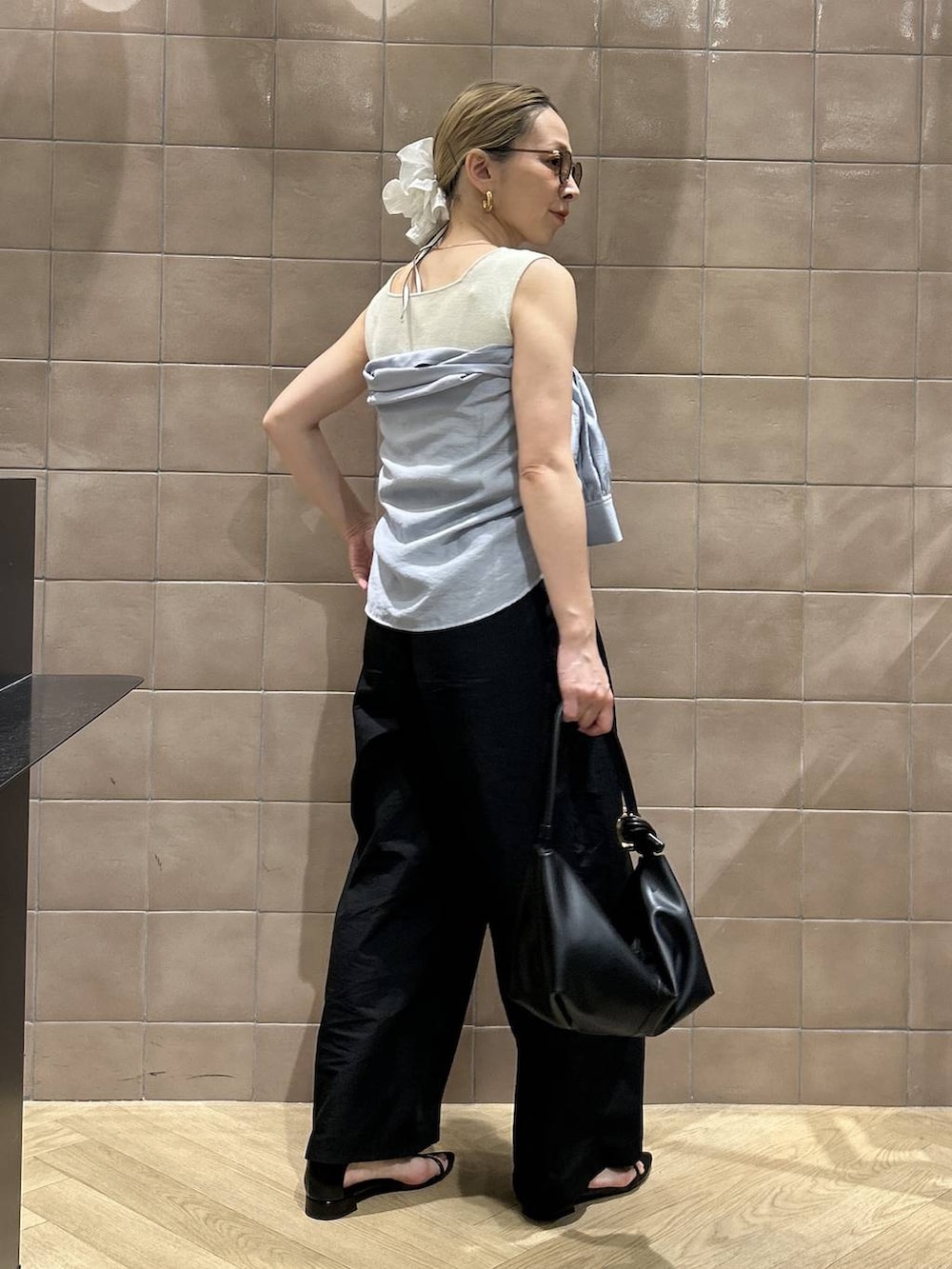 ブラック系のショルダーバッグ、ブルー系のシャツ/ブラウス、ホワイト系のタンクトップを着用したレディースの春コーディネートの7枚目の写真