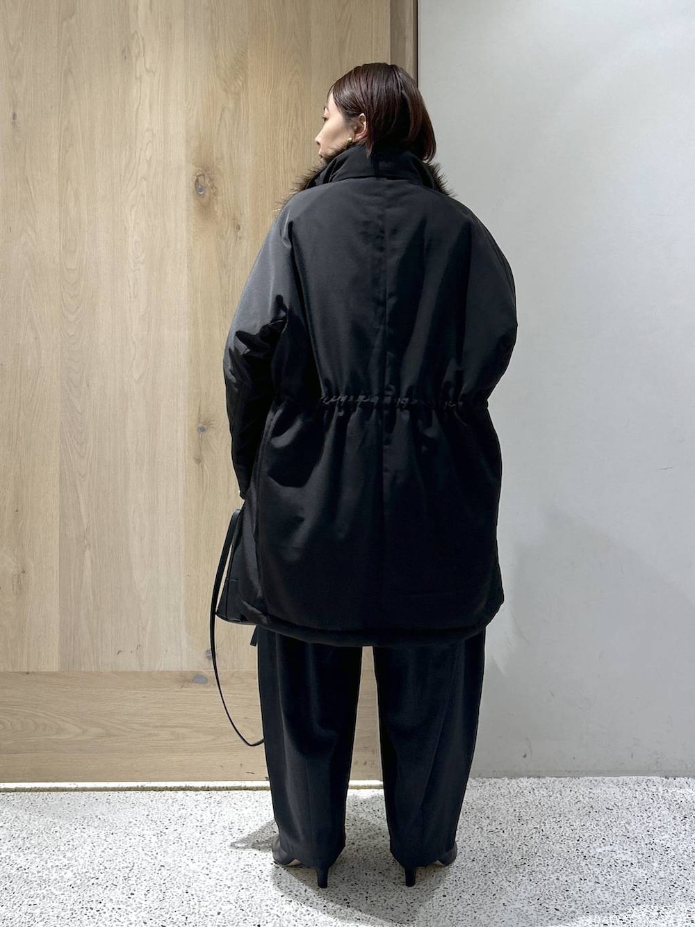 ブラック系のショルダーバッグ、ブラック系のモッズコート、グレー系のニット/セーターを着用したレディースの秋コーディネートの5枚目の写真