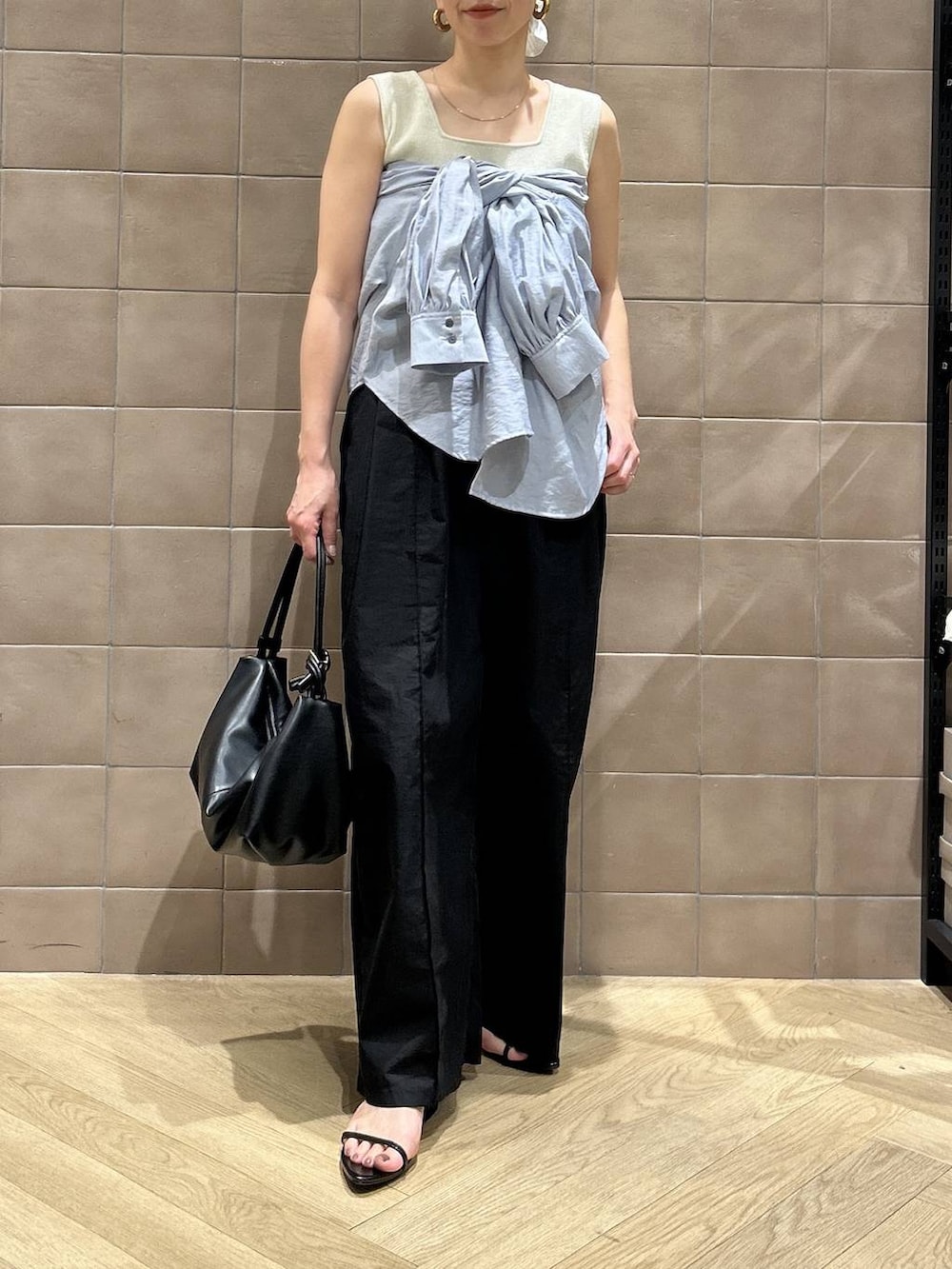 ブラック系のショルダーバッグ、ブルー系のシャツ/ブラウス、ホワイト系のタンクトップを着用したレディースの春コーディネートの4枚目の写真