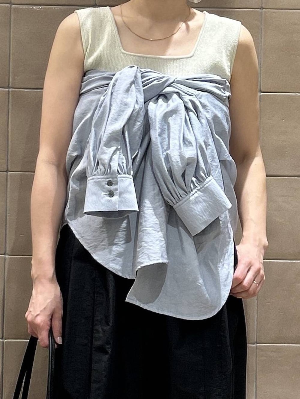 ブラック系のショルダーバッグ、ブルー系のシャツ/ブラウス、ホワイト系のタンクトップを着用したレディースの春コーディネートの2枚目の写真