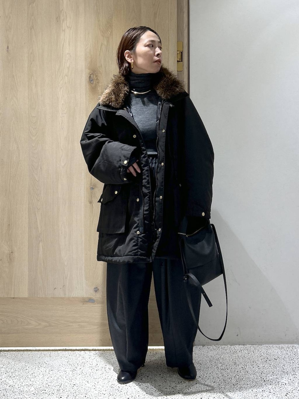 ブラック系のショルダーバッグ、ブラック系のモッズコート、グレー系のニット/セーターを着用したレディースの秋コーディネートの3枚目の写真