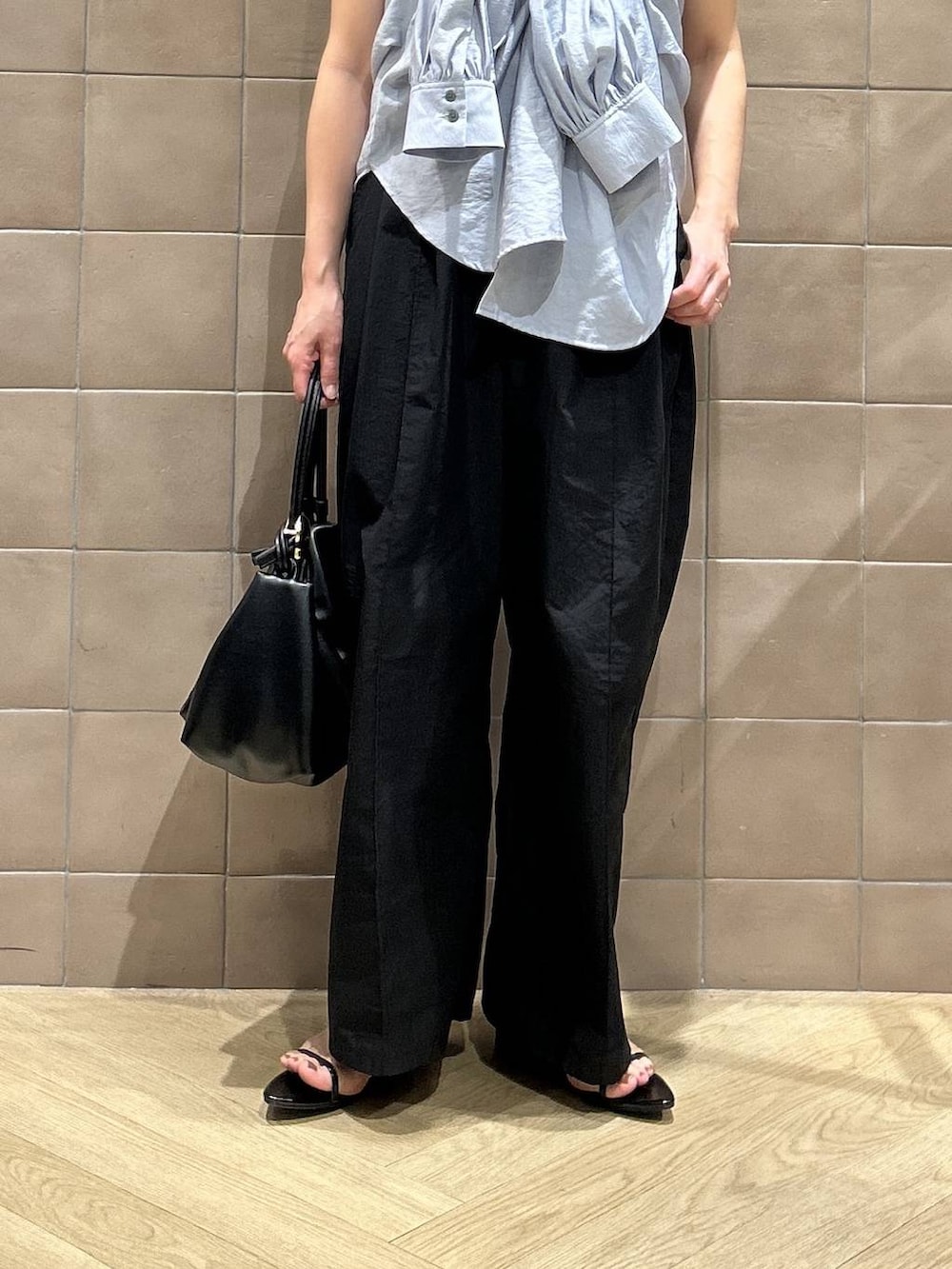 ブラック系のショルダーバッグ、ブルー系のシャツ/ブラウス、ホワイト系のタンクトップを着用したレディースの春コーディネートの3枚目の写真