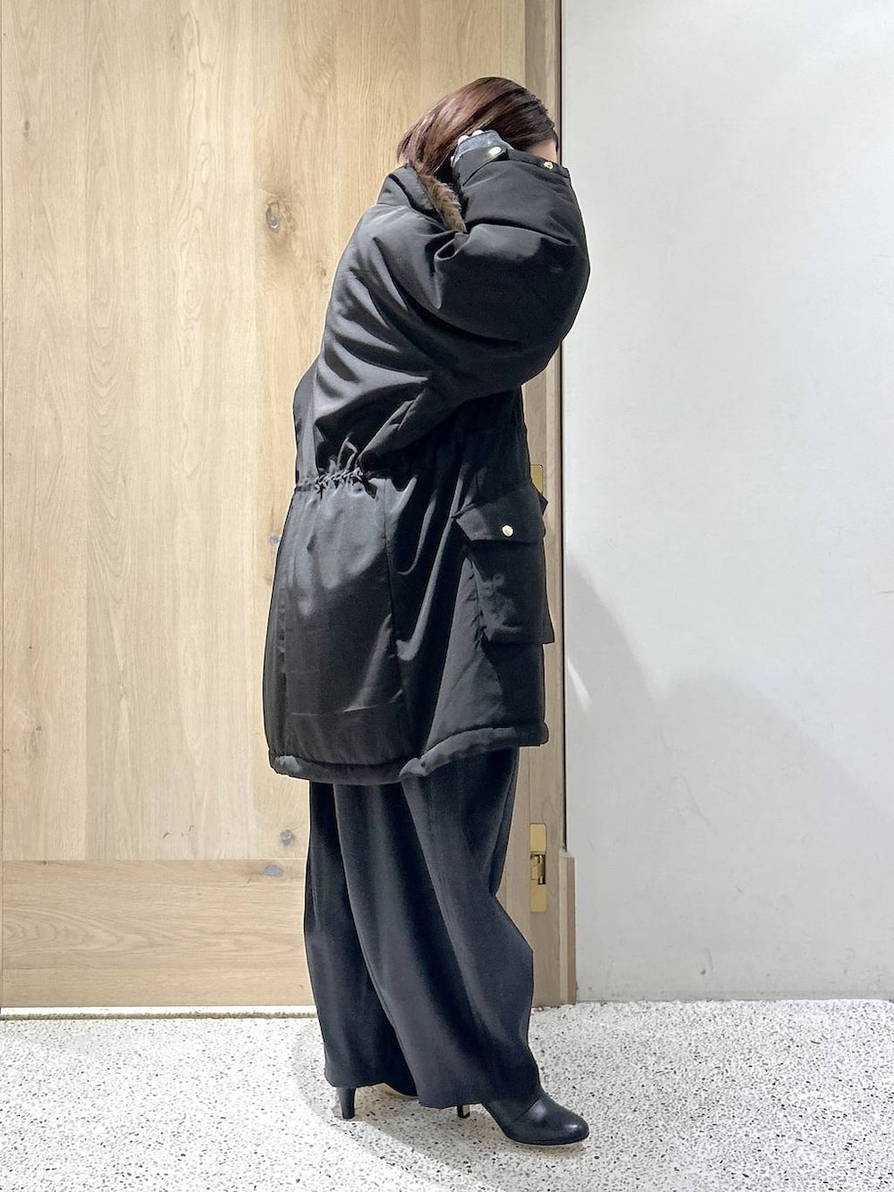 ブラック系のショルダーバッグ、ブラック系のモッズコート、グレー系のニット/セーターを着用したレディースの秋コーディネートの4枚目の写真