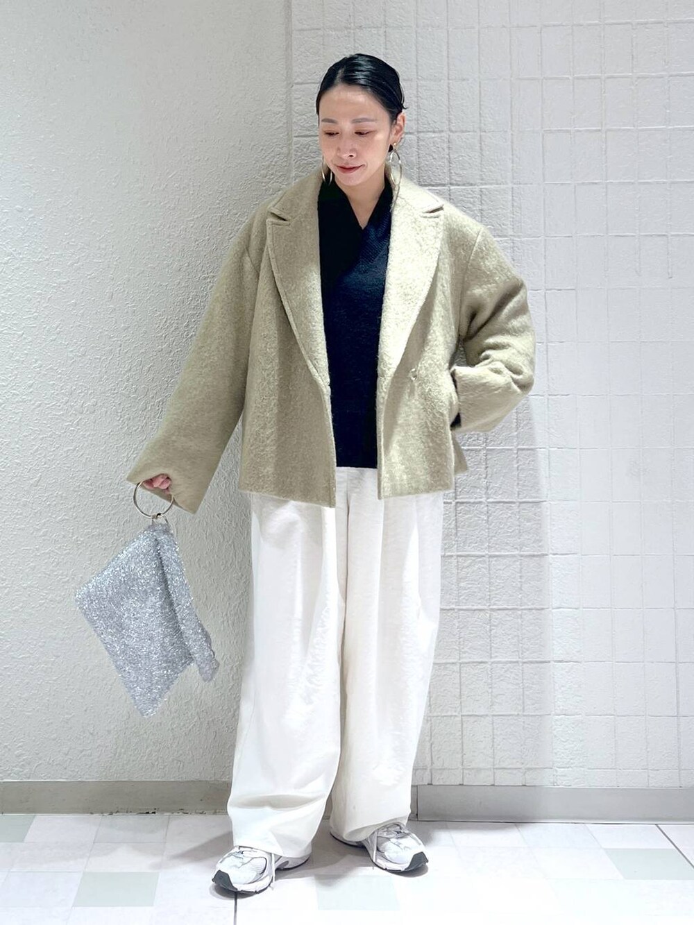 ブルー系のニット/セーター、ホワイト系のその他パンツ、シルバー系のクラッチバッグを着用したレディースの冬コーディネートの5枚目の写真