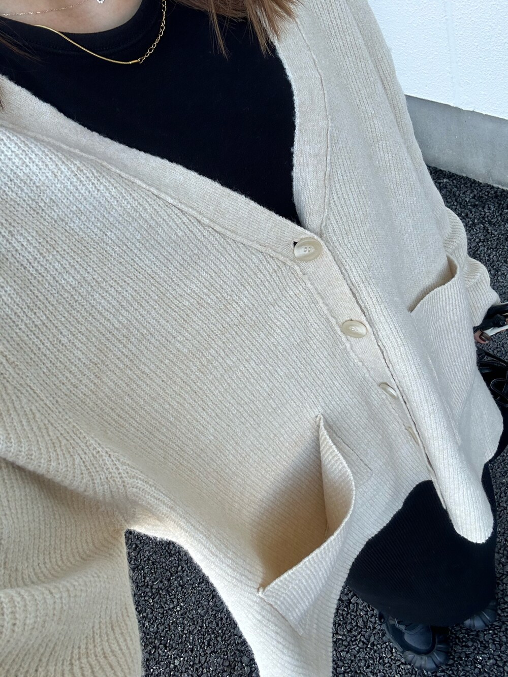 ブラック系のスカート、ホワイト系のカーディガン/ボレロ、ブラック系のその他トップスを着用したレディースの秋コーディネートの3枚目の写真
