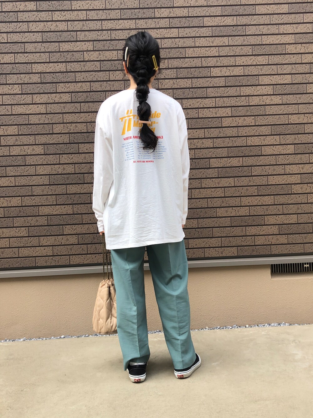 グリーン系のその他パンツ、ホワイト系のTシャツ/カットソー、ブラック系のスニーカーを着用したレディースの春コーディネートの2枚目の写真