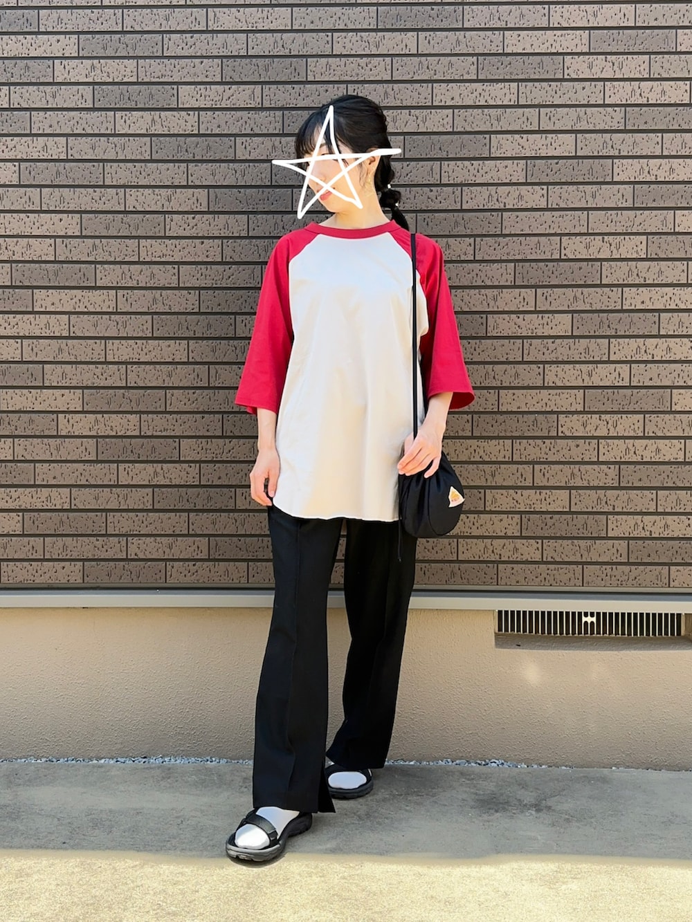 ブラック系のスラックス、レッド系のTシャツ/カットソー、ブラック系のサンダルを着用したレディースの夏コーディネートの2枚目の写真