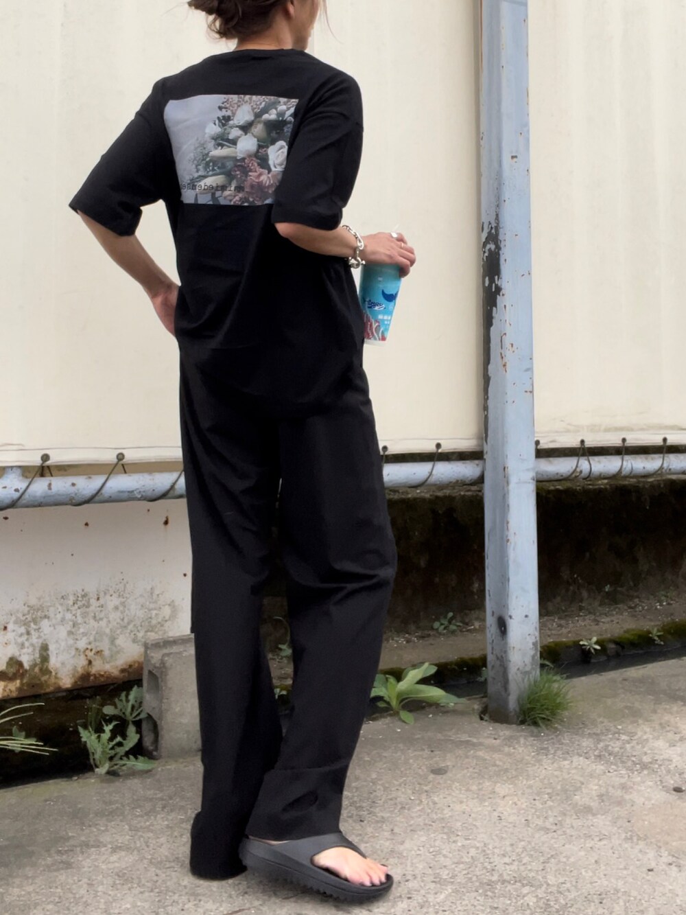 ブラック系のスラックスを着用したレディースの夏コーディネートの3枚目の写真