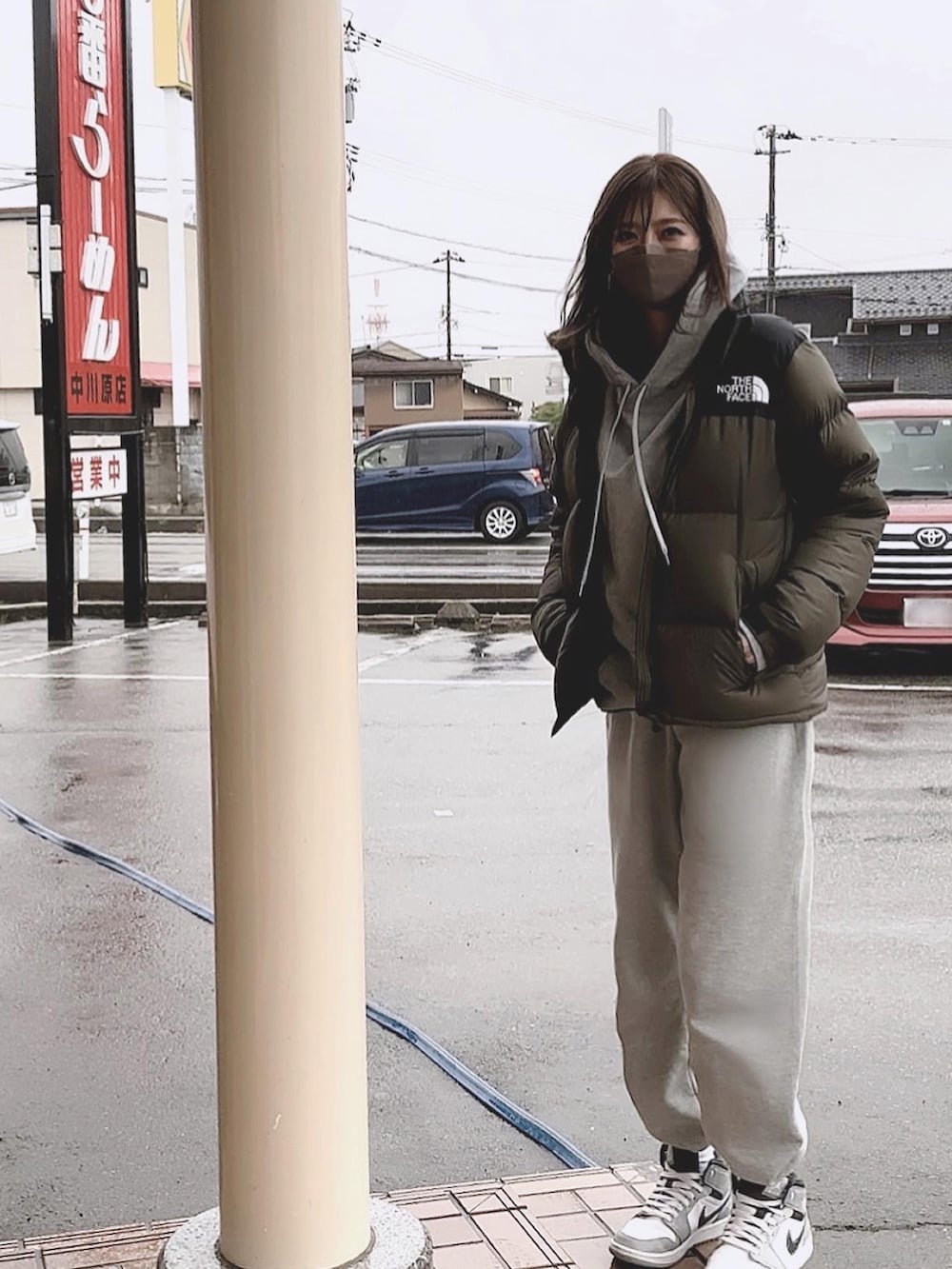 グリーン系のダウンジャケット/コート、グレー系のスウェットパンツ、グレー系のスニーカーを着用したレディースの冬コーディネートの2枚目の写真