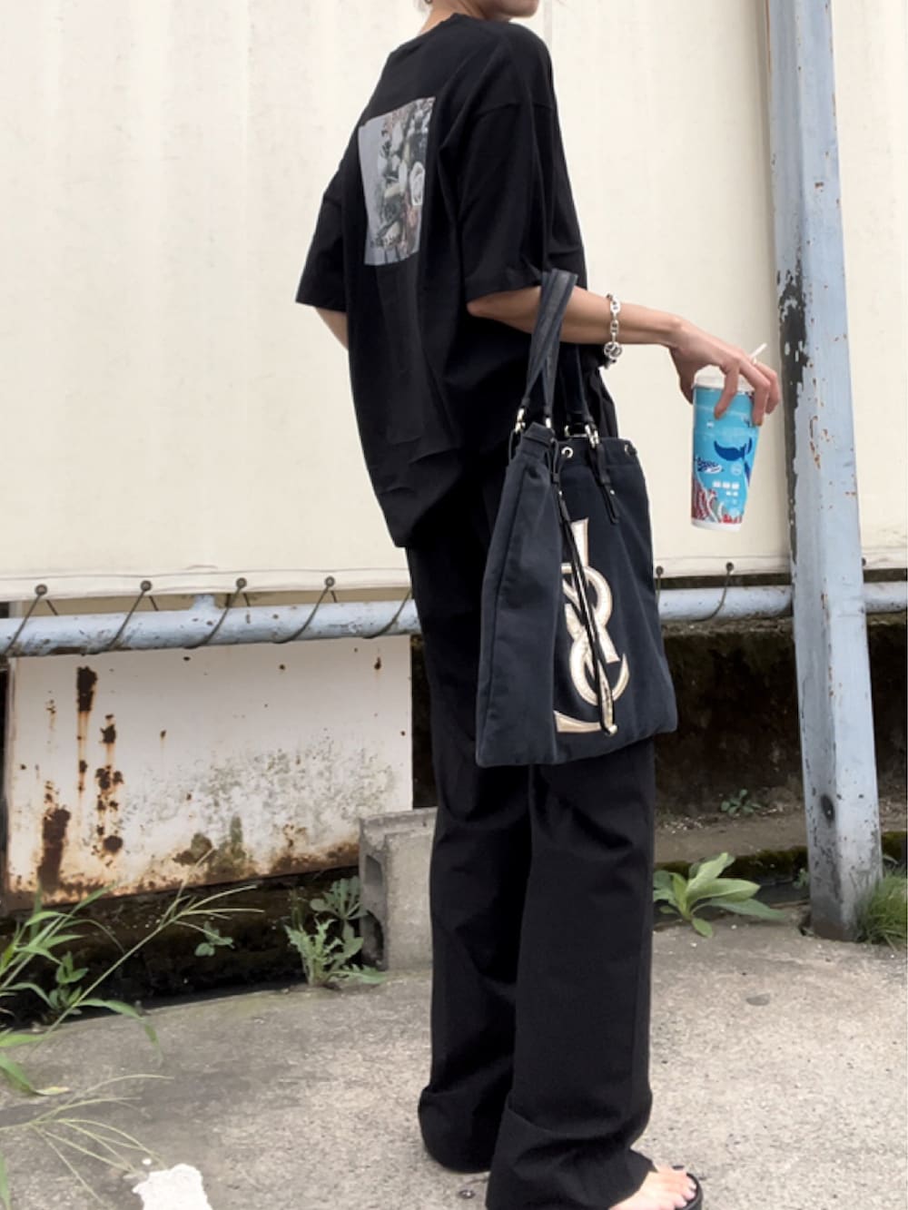 ブラック系のスラックスを着用したレディースの夏コーディネートの2枚目の写真