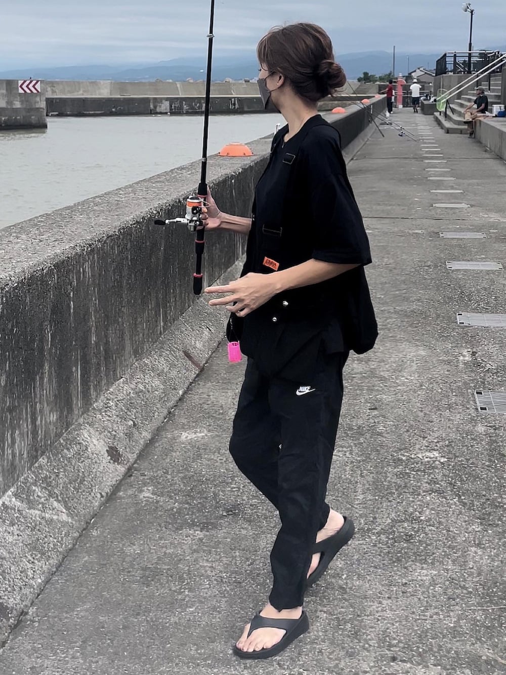 ブラック系のベスト、ブラック系のパンツを着用したレディースの夏コーディネートの2枚目の写真