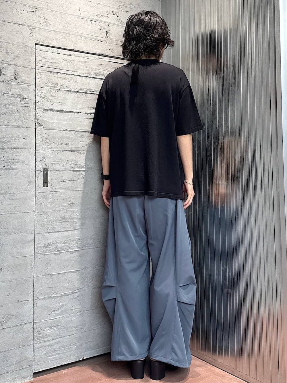 ホワイト系のタンクトップ、ブラック系のサンダル、ブルー系のカーゴパンツを着用したメンズの夏コーディネートの3枚目の写真