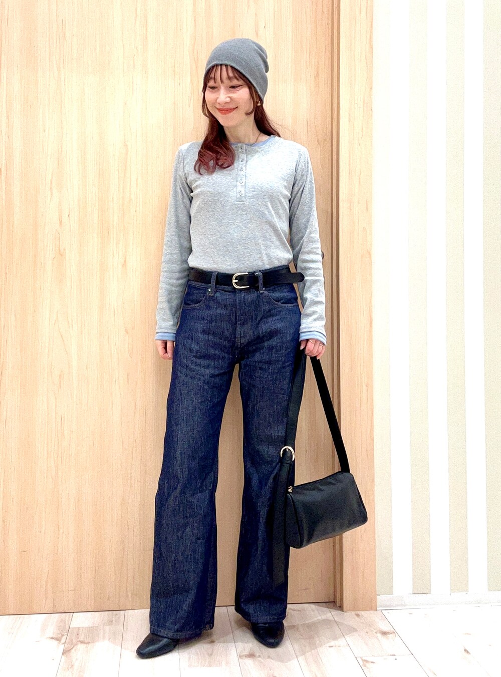 グレー系のTシャツ/カットソー、ブルー系のデニムパンツ、ブラック系のショルダーバッグを着用したレディースの春コーディネートの2枚目の写真