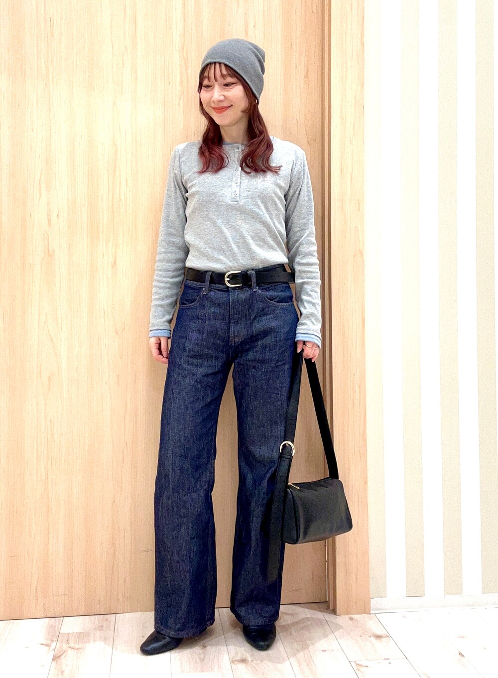 グレー系のTシャツ/カットソー、ブルー系のデニムパンツ、ブラック系のショルダーバッグを着用したレディースの春コーディネートの3枚目の写真