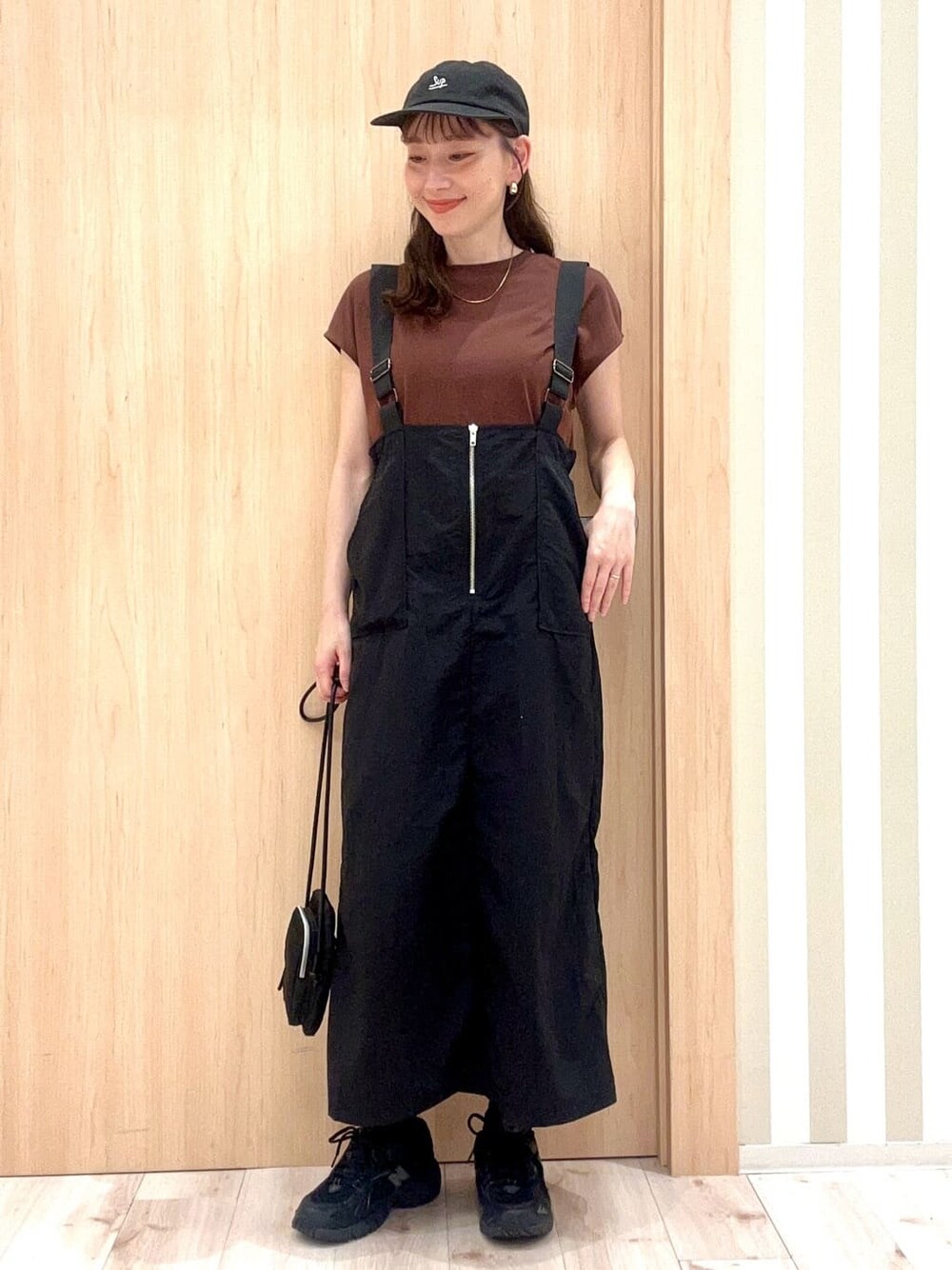 ブラウン系のTシャツ/カットソー、ブラック系のワンピース、ブラック系のショルダーバッグを着用したレディースの夏コーディネートの2枚目の写真