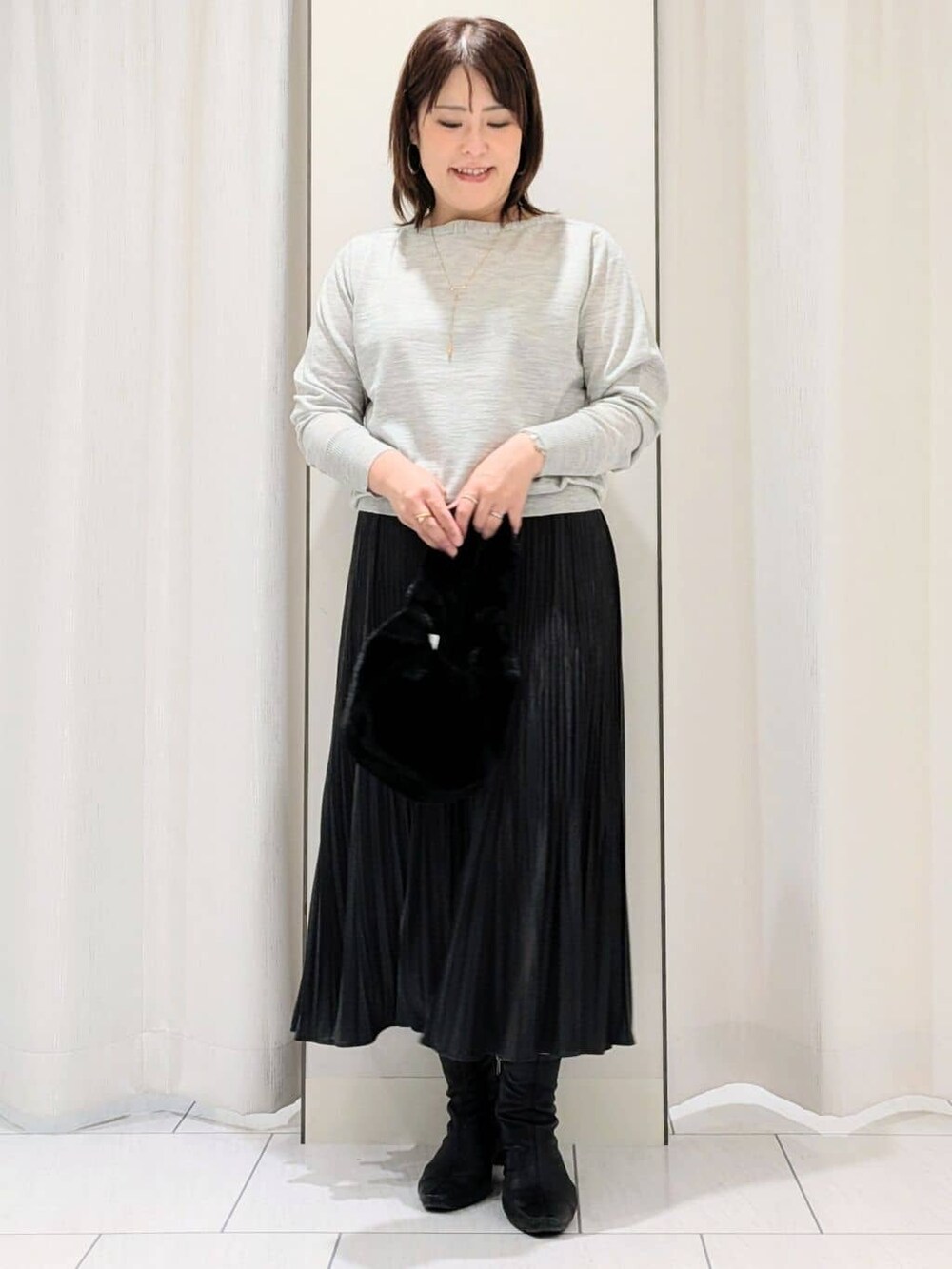 グレー系のカーディガン/ボレロ、グレー系のニット/セーター、グレー系のスカートを着用したレディースの冬コーディネートの7枚目の写真