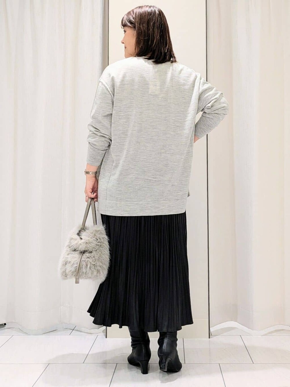 グレー系のカーディガン/ボレロ、グレー系のニット/セーター、グレー系のスカートを着用したレディースの冬コーディネートの4枚目の写真