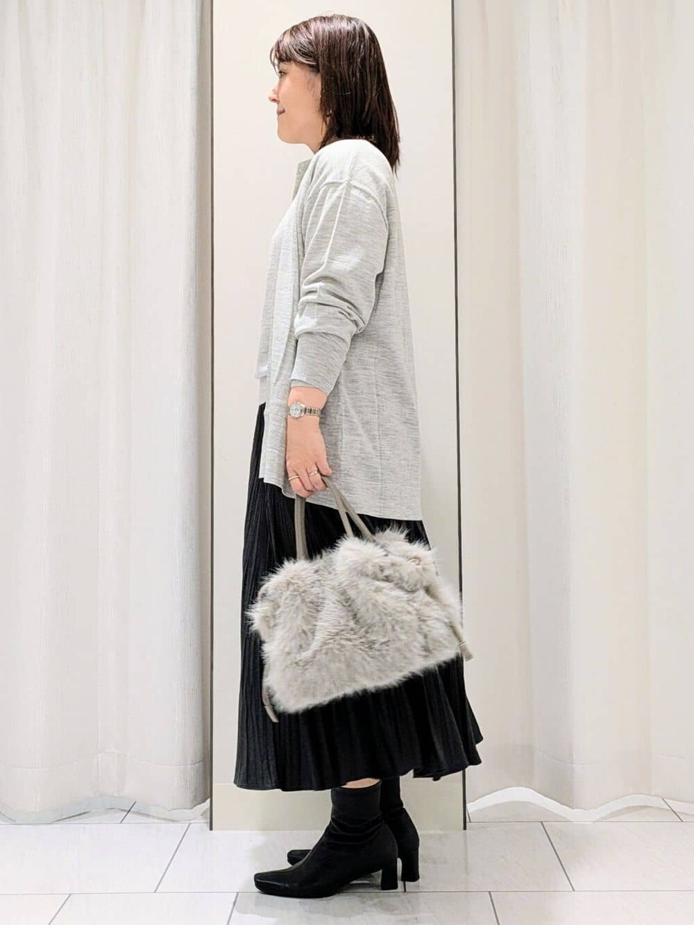グレー系のカーディガン/ボレロ、グレー系のニット/セーター、グレー系のスカートを着用したレディースの冬コーディネートの5枚目の写真