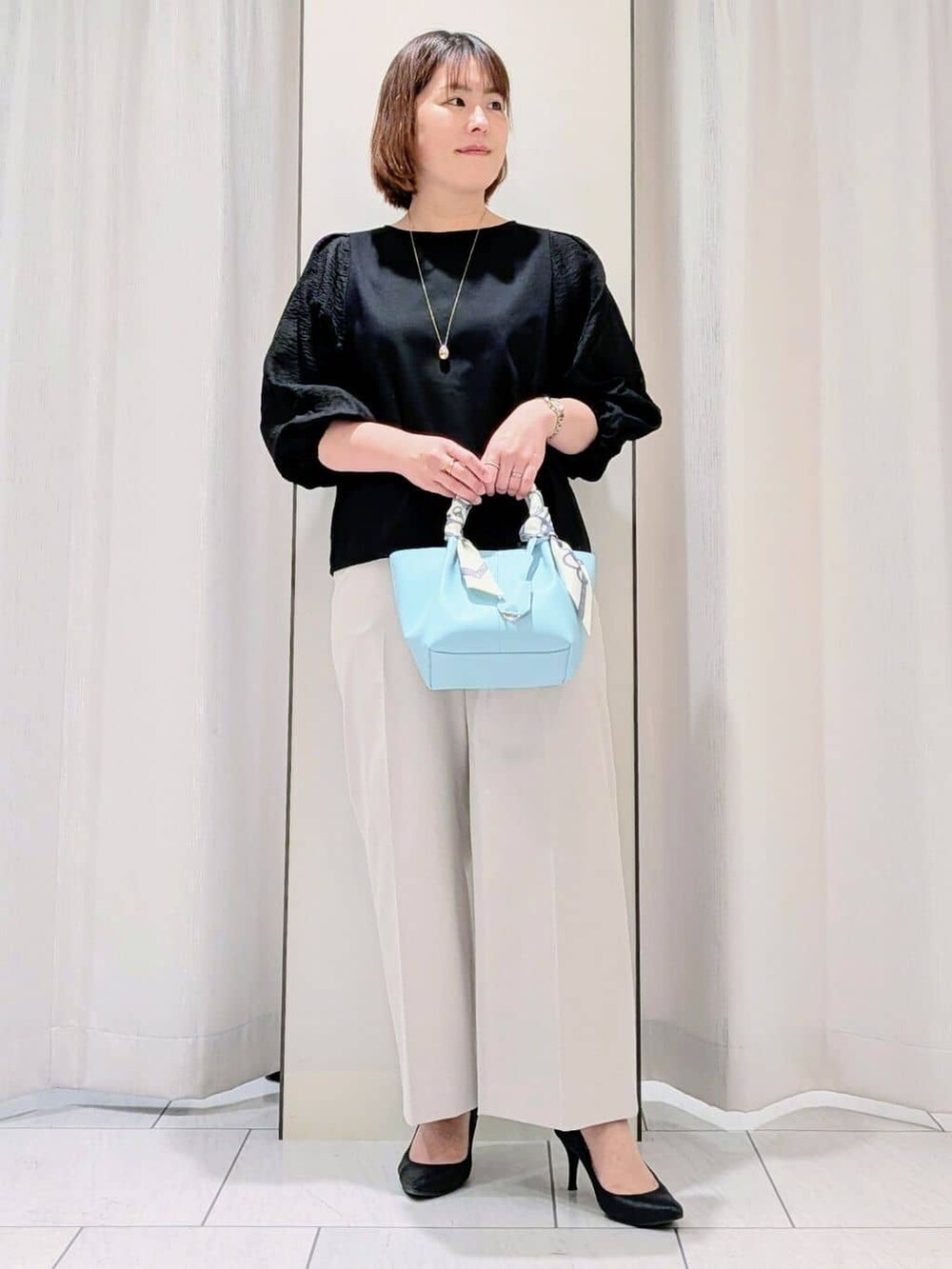 ベージュ系のトレンチコート、ブラック系のTシャツ/カットソー、ベージュ系のその他パンツを着用したレディースの春コーディネートの5枚目の写真