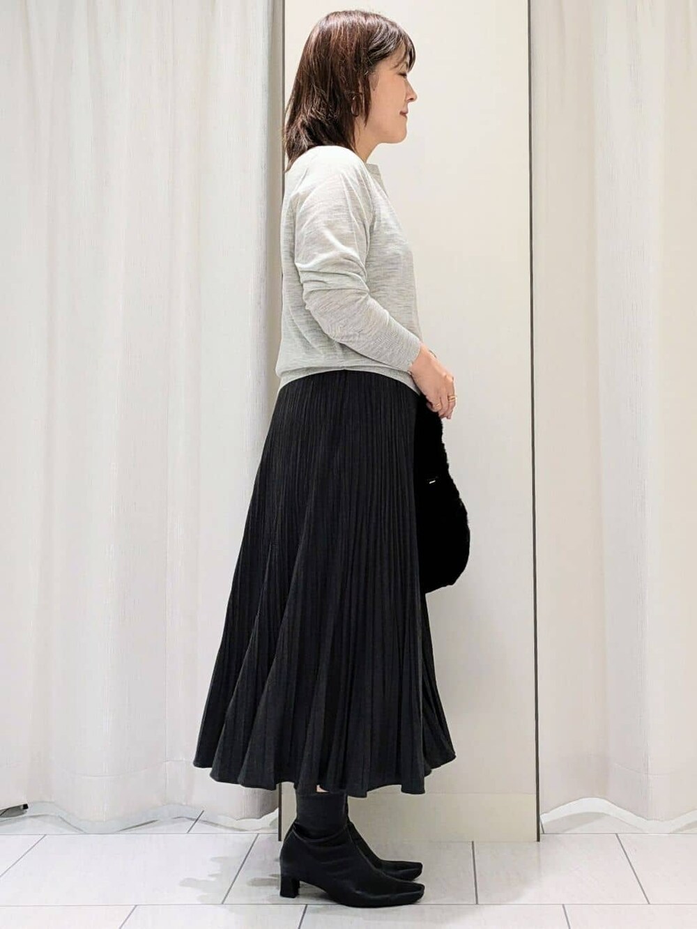 グレー系のカーディガン/ボレロ、グレー系のニット/セーター、グレー系のスカートを着用したレディースの冬コーディネートの8枚目の写真