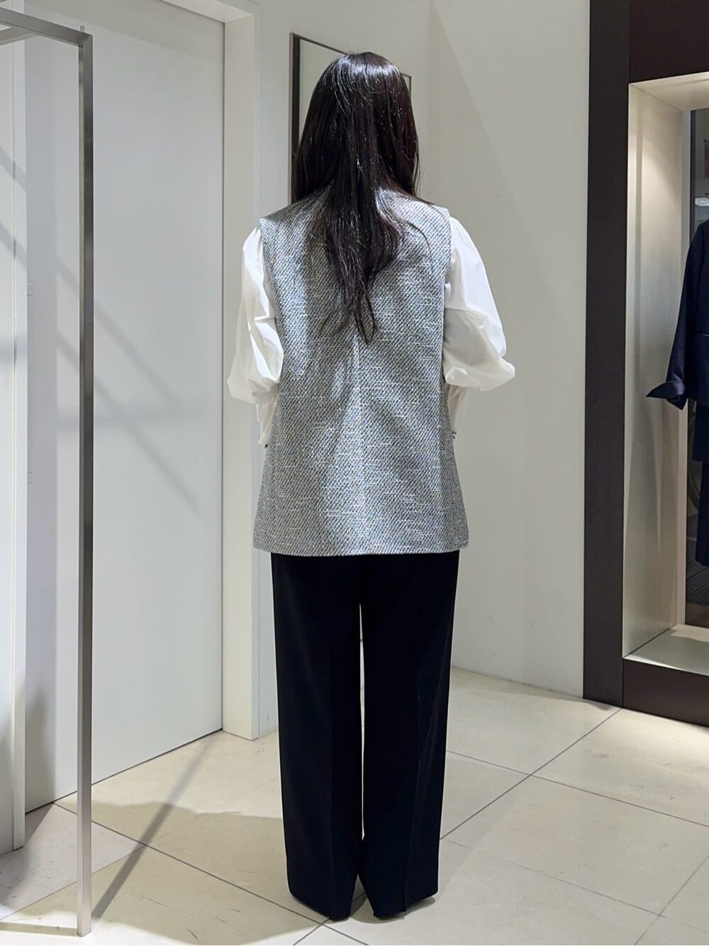 ブラック系のベスト、ホワイト系のシャツ/ブラウス、ブラック系のその他パンツを着用したレディースの冬コーディネートの3枚目の写真