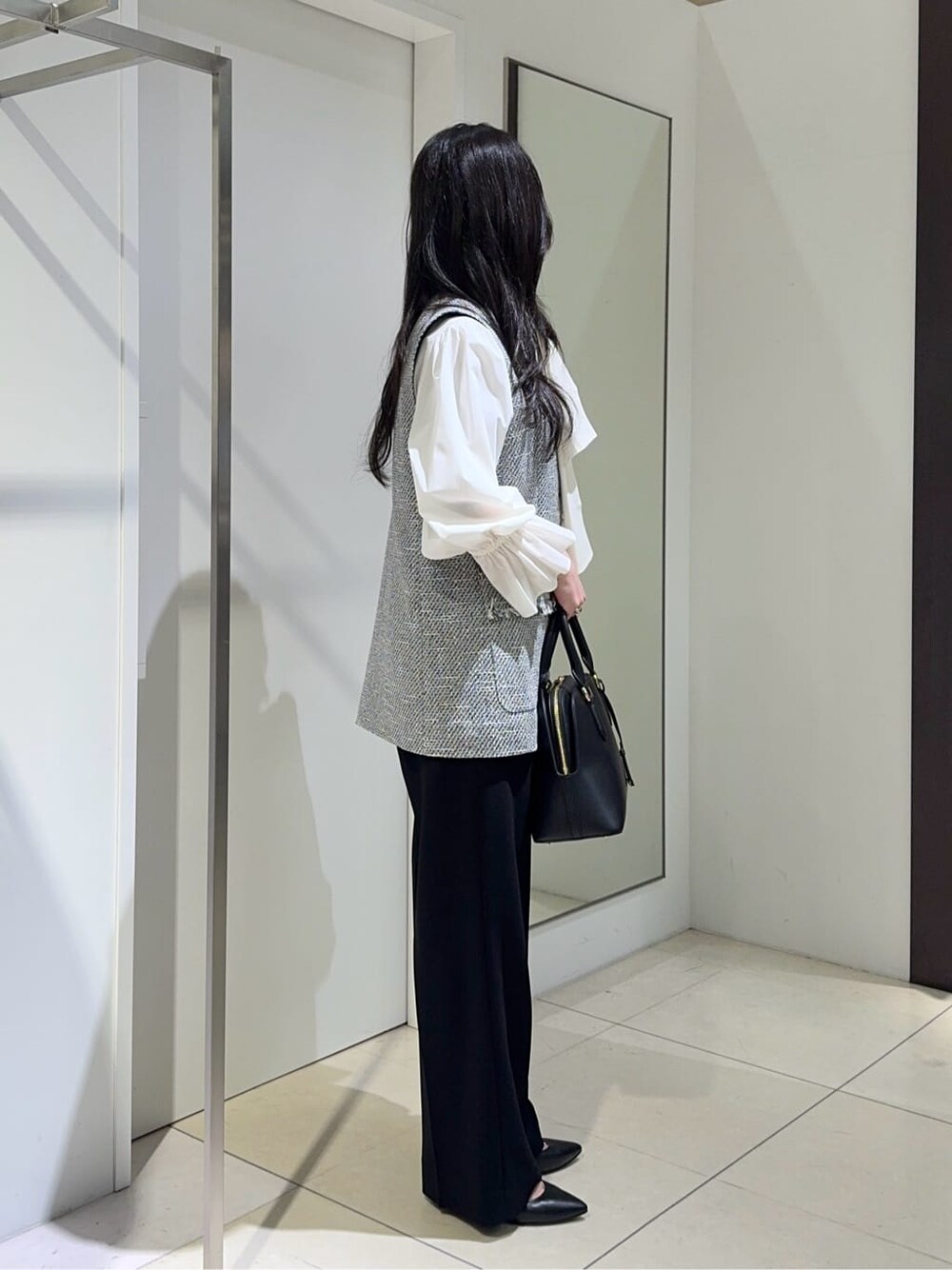 ブラック系のベスト、ホワイト系のシャツ/ブラウス、ブラック系のその他パンツを着用したレディースの冬コーディネートの2枚目の写真