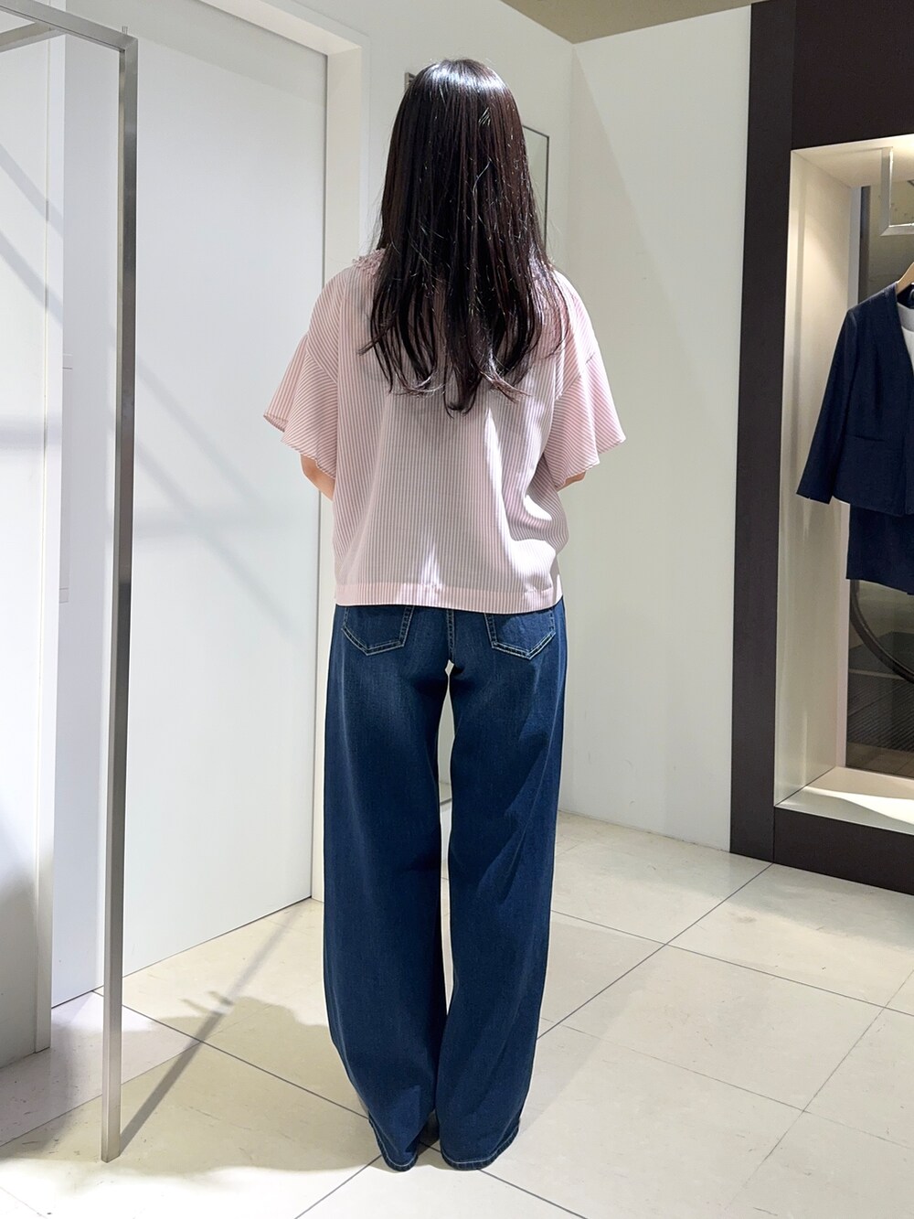 ブルー系のデニムパンツ、ブラック系のパンプスを着用したレディースの春コーディネートの3枚目の写真