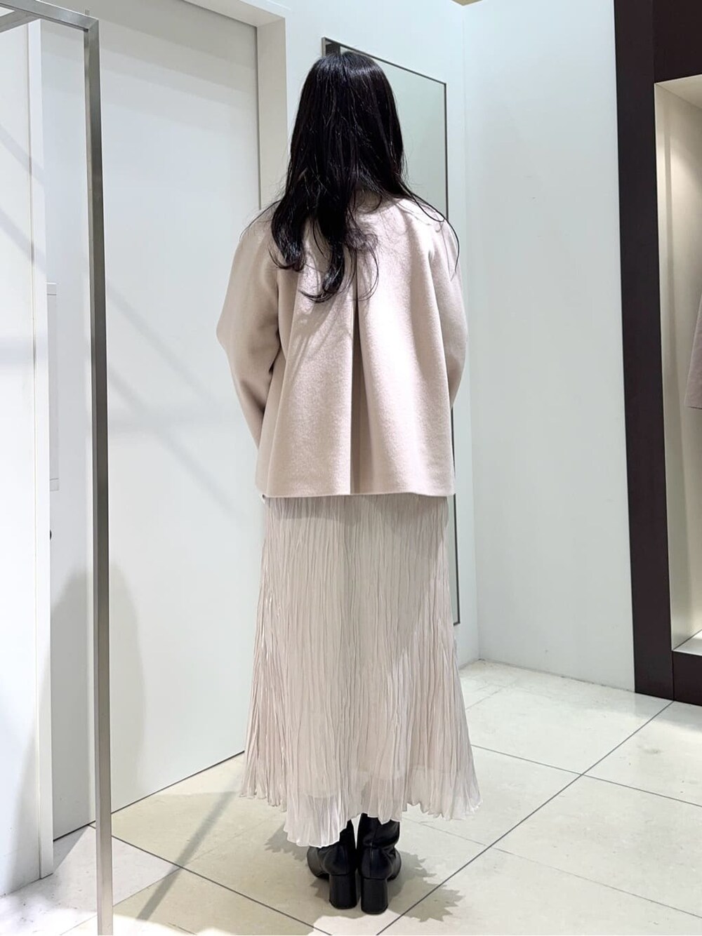 ベージュ系のその他アウター、レッド系のニット/セーター、ベージュ系のスカートを着用したレディースの冬コーディネートの3枚目の写真