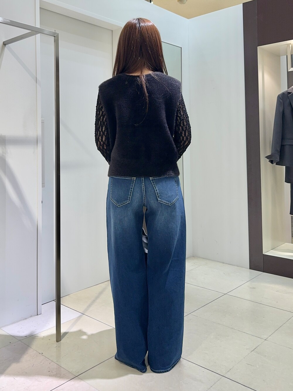 ブラック系のカーディガン/ボレロ、ブラック系のTシャツ/カットソー、ブルー系のデニムパンツを着用したレディースの秋コーディネートの4枚目の写真