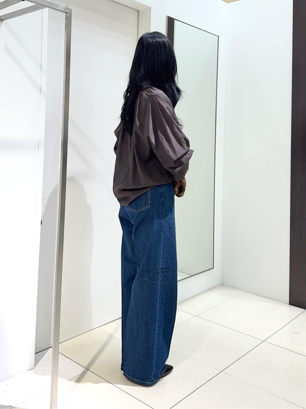 ブラウン系のシャツ/ブラウス、ブルー系のデニムパンツ、ブラック系のパンプスを着用したレディースの夏コーディネートの2枚目の写真