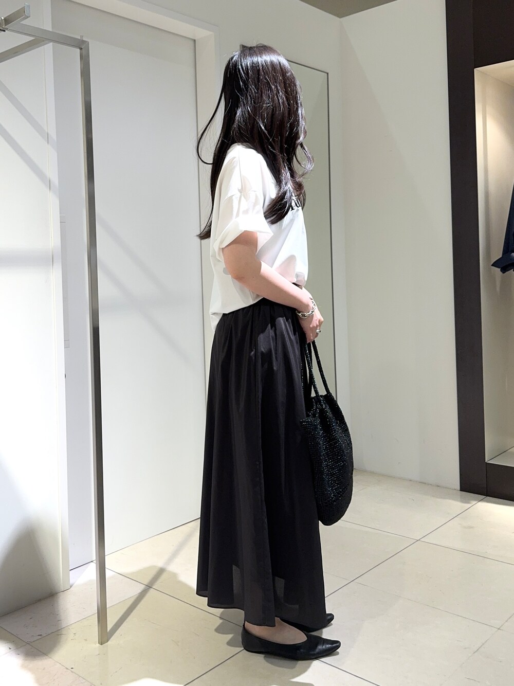 ホワイト系のTシャツ/カットソー、ブラウン系のスカートを着用したレディースの春コーディネートの2枚目の写真