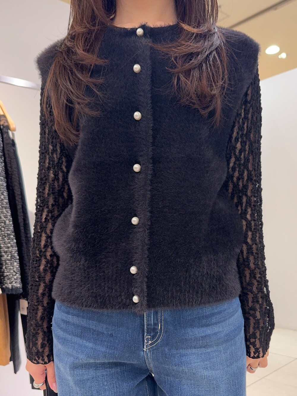 ブラック系のカーディガン/ボレロ、ブラック系のTシャツ/カットソー、ブルー系のデニムパンツを着用したレディースの秋コーディネートの2枚目の写真