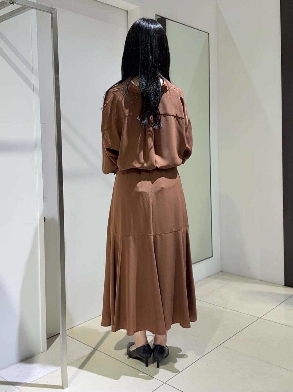 ブラウン系のシャツ/ブラウス、ブラウン系のスカート、ブラック系のパンプスを着用したレディースの秋コーディネートの3枚目の写真