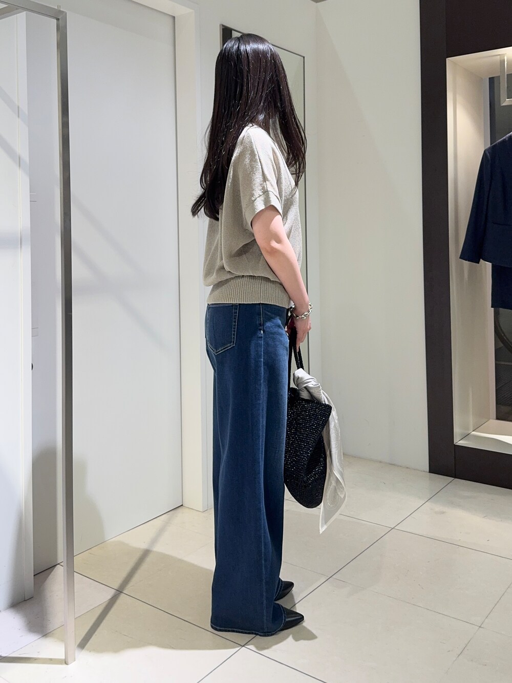 グリーン系のカーディガン/ボレロ、ブルー系のデニムパンツ、ブラック系のパンプスを着用したレディースの春コーディネートの2枚目の写真