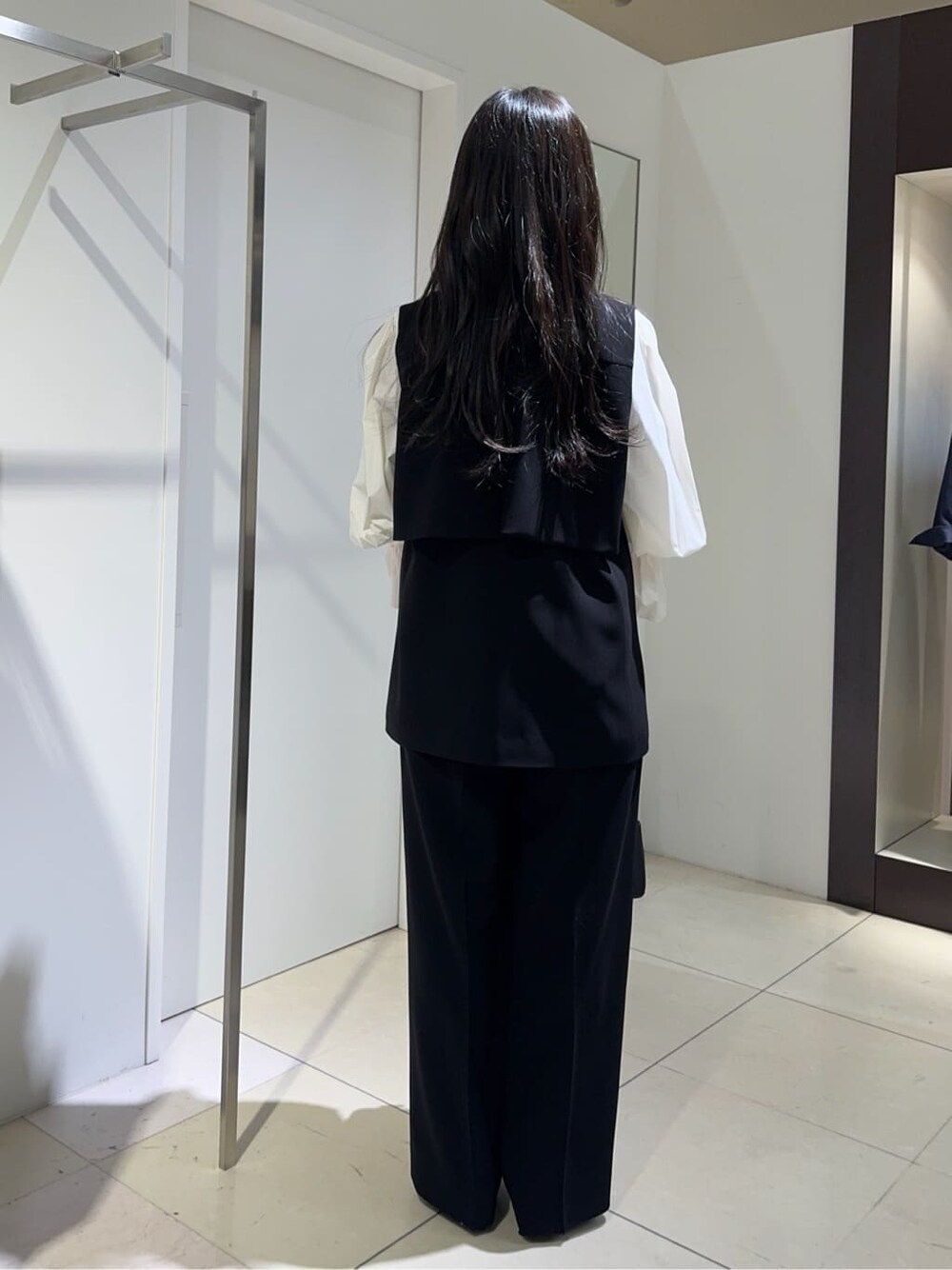 ブラック系のベスト、ホワイト系のシャツ/ブラウス、ブラック系のその他パンツを着用したレディースの冬コーディネートの3枚目の写真