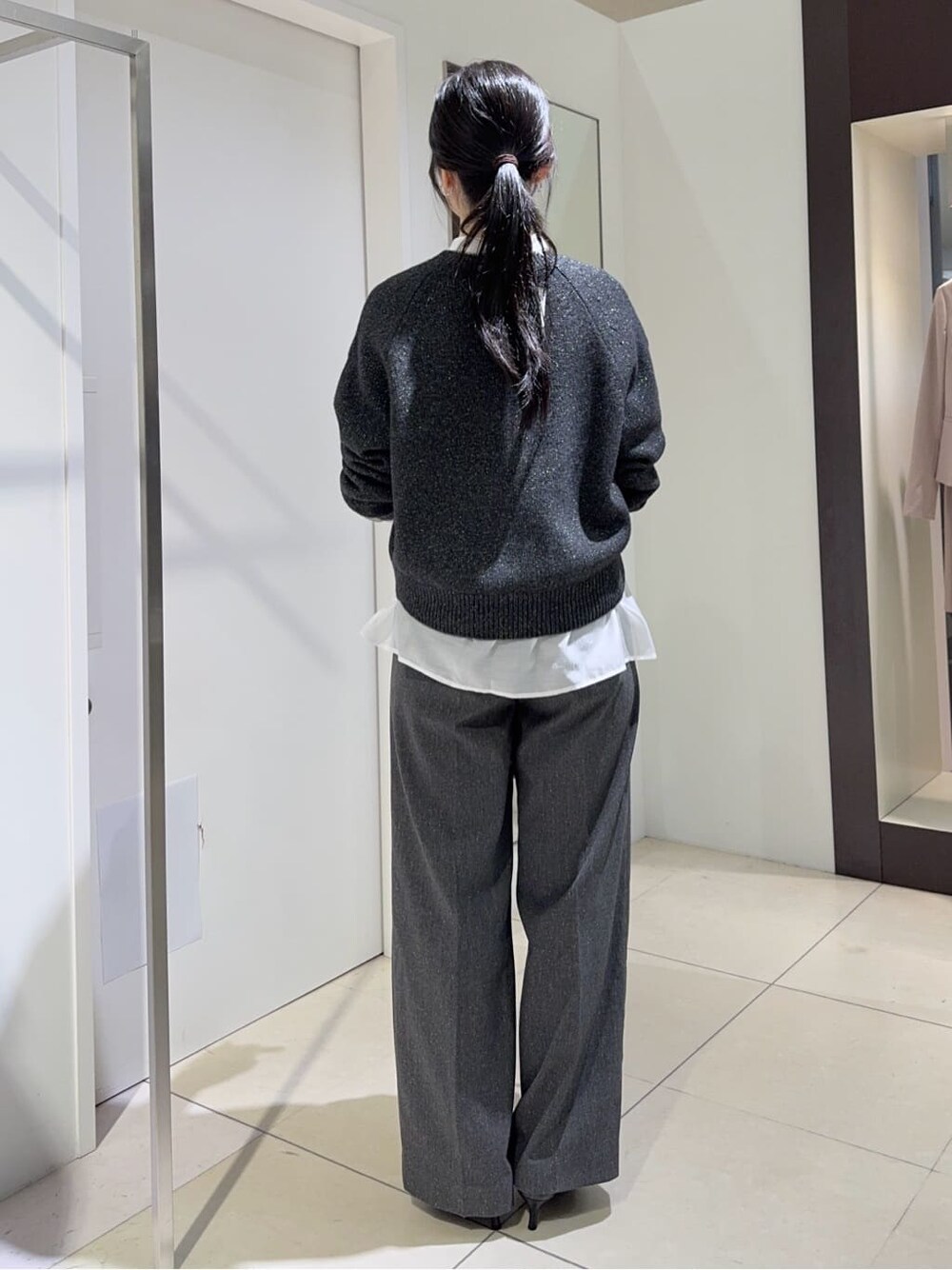グレー系のニット/セーター、ホワイト系のシャツ/ブラウス、グレー系のその他パンツを着用したレディースの秋コーディネートの2枚目の写真