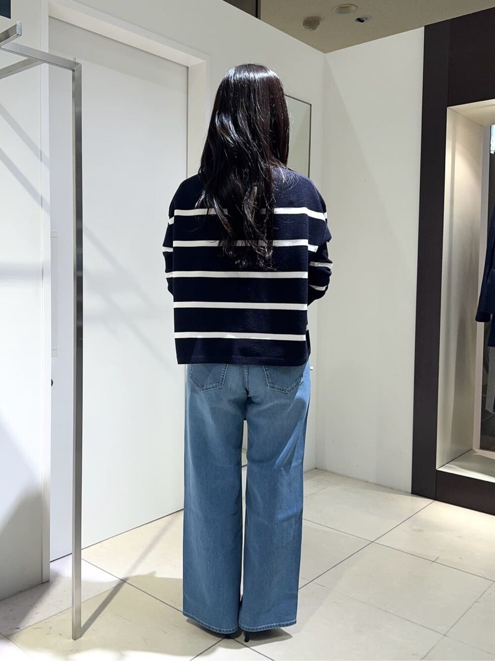 ブルー系のニット/セーター、ブルー系のデニムパンツ、ブラック系のパンプスを着用したレディースの春コーディネートの3枚目の写真
