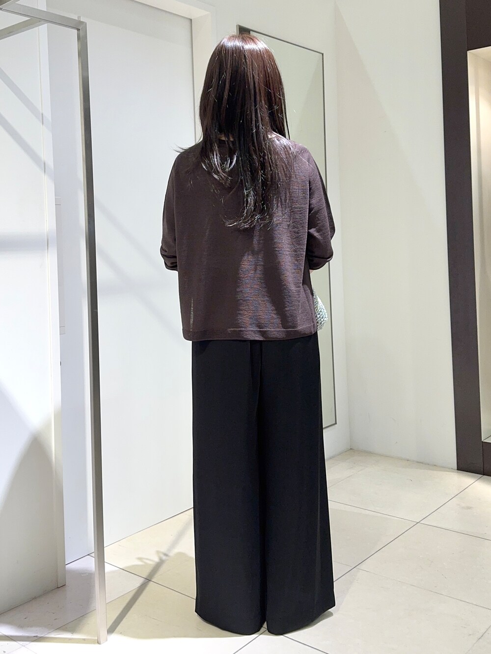 ブラウン系のニット/セーター、ブラック系のその他パンツ、シルバー系のトートバッグを着用したレディースの夏コーディネートの3枚目の写真