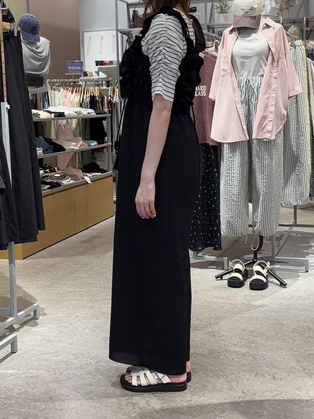 ホワイト系のサンダル、ブラック系のトートバッグ、ホワイト系のTシャツ/カットソーを着用したレディースの春コーディネートの2枚目の写真