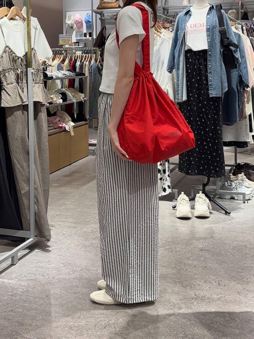 ホワイト系のTシャツ/カットソー、ホワイト系のスニーカー、レッド系のショルダーバッグを着用したレディースの春コーディネートの2枚目の写真