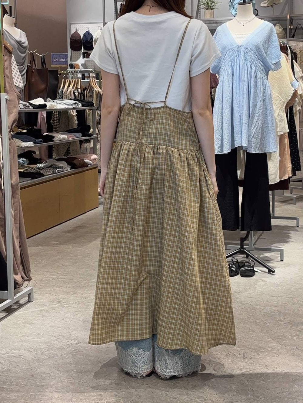 ブルー系のデニムパンツ、ホワイト系のTシャツ/カットソー、ブラック系のサンダルを着用したレディースの夏コーディネートの3枚目の写真