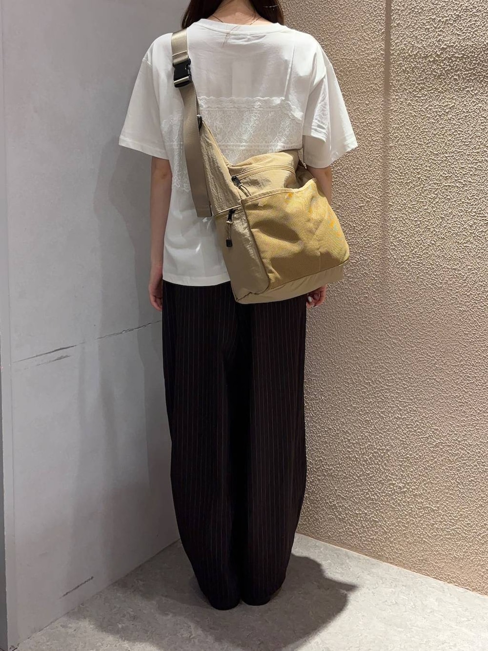 ベージュ系のショルダーバッグ、ホワイト系のTシャツ/カットソー、ブラウン系のその他パンツを着用したレディースの夏コーディネートの3枚目の写真