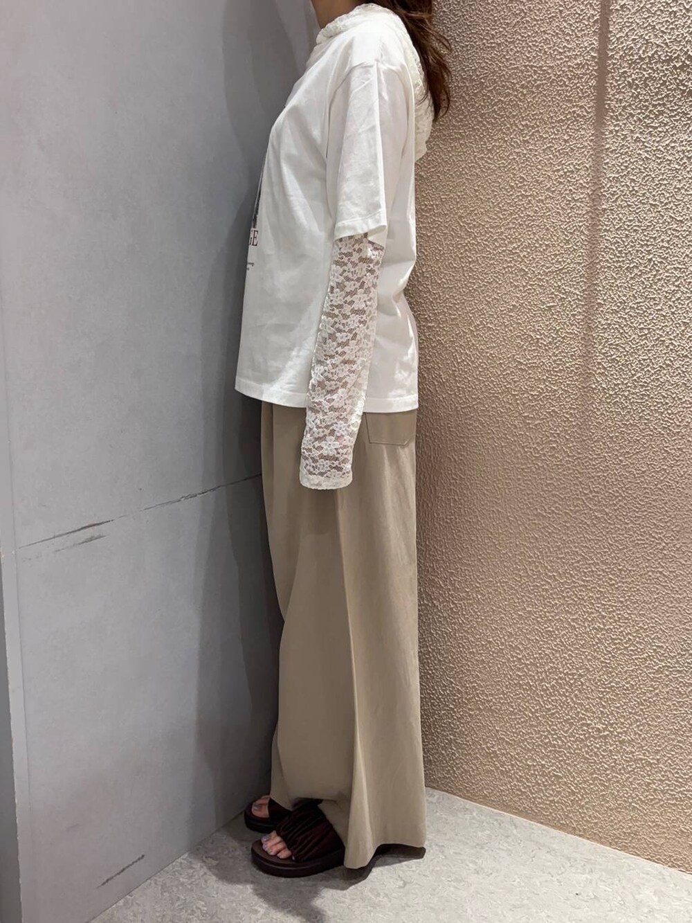 ベージュ系のデニムパンツ、ブラウン系のサンダルを着用したレディースの夏コーディネートの2枚目の写真
