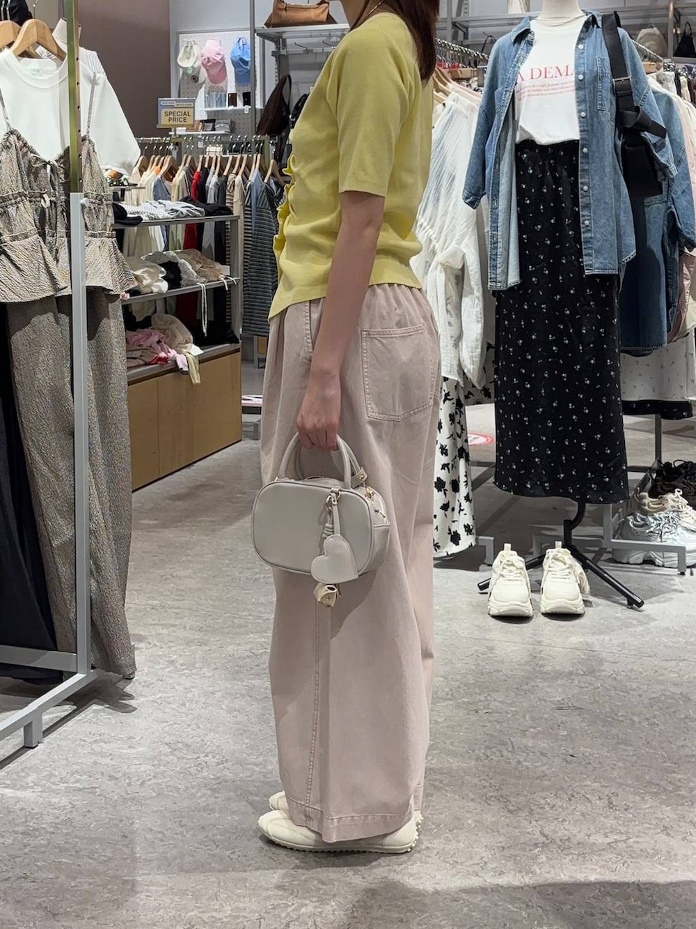 ホワイト系のボストンバッグ、ピンク系のデニムパンツ、ホワイト系のスニーカーを着用したレディースの春コーディネートの2枚目の写真